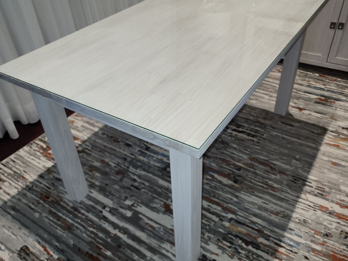 Clear glass protector on a whitewash dining table